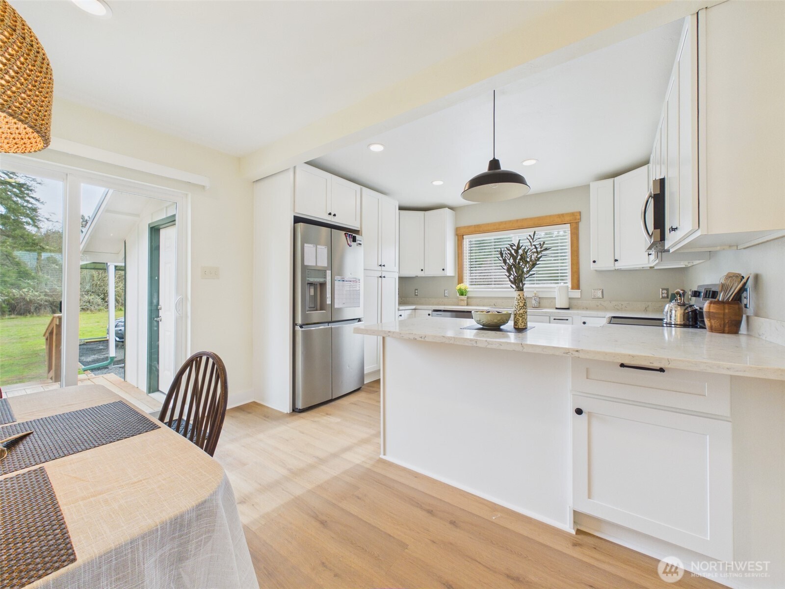 481 Kirkland Road Chehalis, WA 98532 - Photo 10 of 40 a kitchen with stainless steel appliances granite countertop a refrigerator a sink dishwasher a dining table and chairs with wooden floor