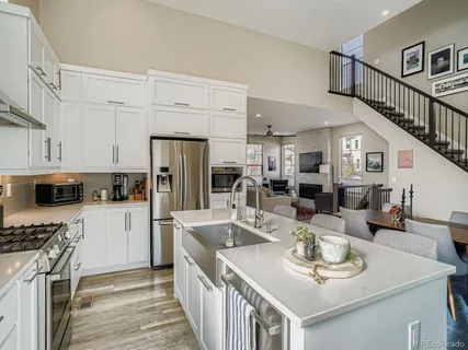 a kitchen with stainless steel appliances granite countertop a sink a stove and refrigerator