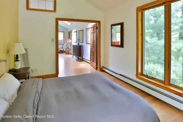 a view of a bedroom with wooden floor and windows