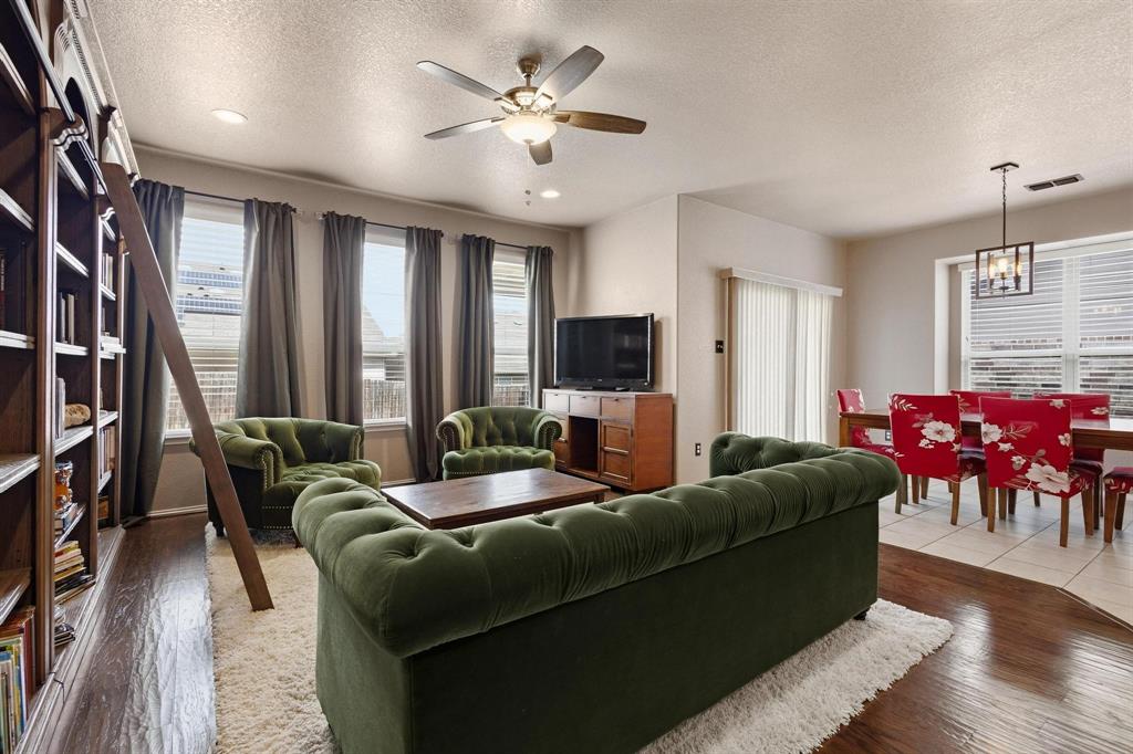 5513 Wharfside Place Denton, TX 76208 - Photo 16 of 37 a living room with furniture and a chandelier