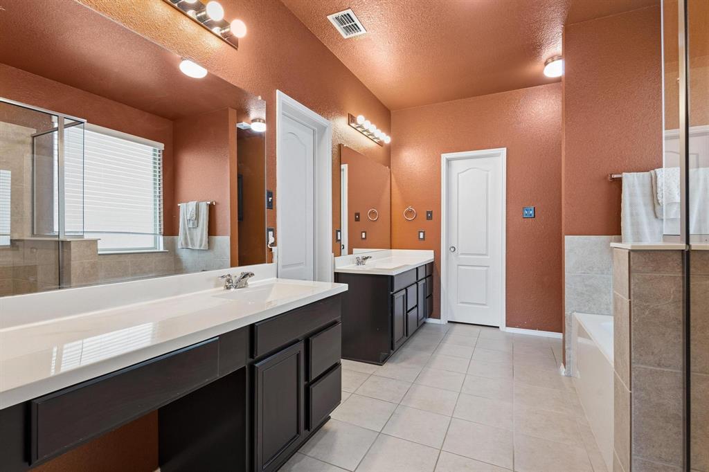5513 Wharfside Place Denton, TX 76208 - Photo 28 of 37 a large bathroom with a double vanity sink a mirror and a bathtub