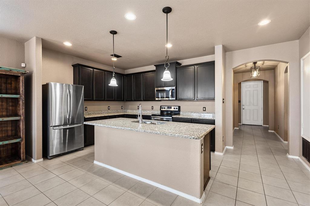 5513 Wharfside Place Denton, TX 76208 - Photo 6 of 37 a kitchen with stainless steel appliances granite countertop a refrigerator a sink and a stove
