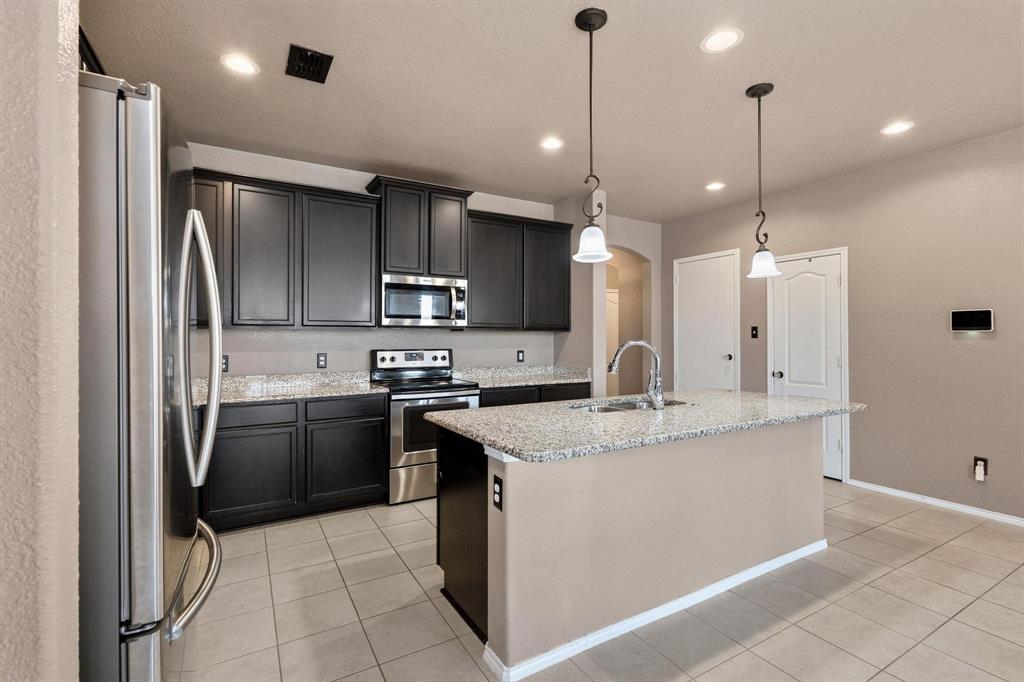 5513 Wharfside Place Denton, TX 76208 - Photo 7 of 37 a kitchen with stainless steel appliances granite countertop a sink a stove a refrigerator and a oven