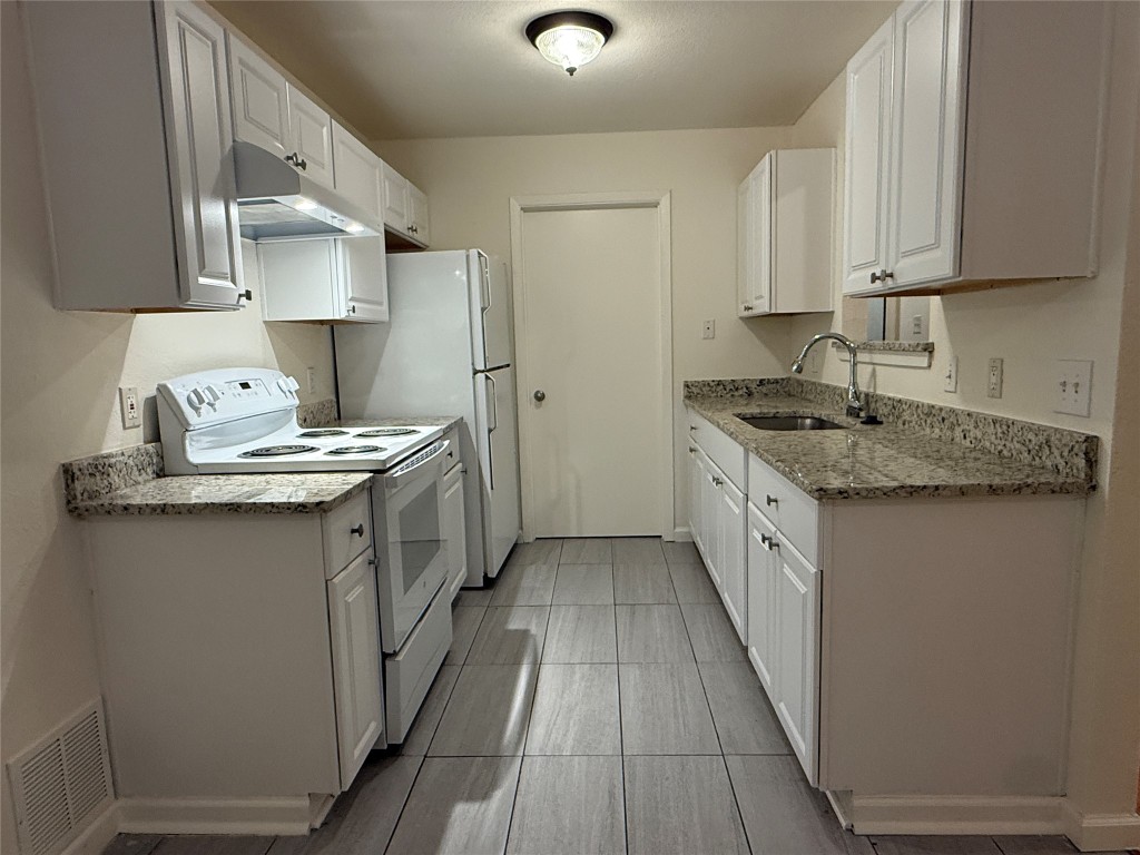 a kitchen with stainless steel appliances granite countertop a sink stove and cabinets