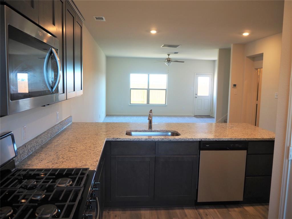 13612 Musselshell Drive Ponder, TX 76259 - Photo 9 of 39 a kitchen with stainless steel appliances a sink stove and cabinets