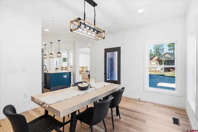 a view of a dining room with furniture a chandelier and wooden floor