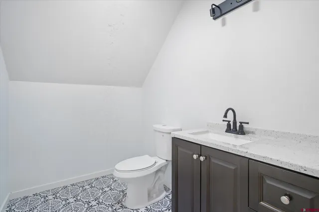 a bathroom with a granite countertop sink a toilet and a mirror