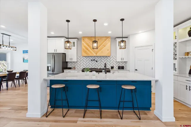 a kitchen with stainless steel appliances granite countertop a sink a stove and a refrigerator