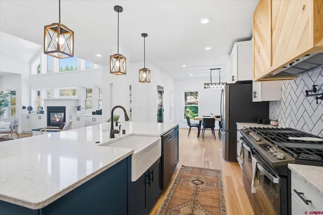 a kitchen with stainless steel appliances granite countertop a sink a stove and a refrigerator