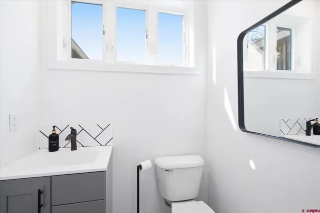 a bathroom with a toilet sink and mirror