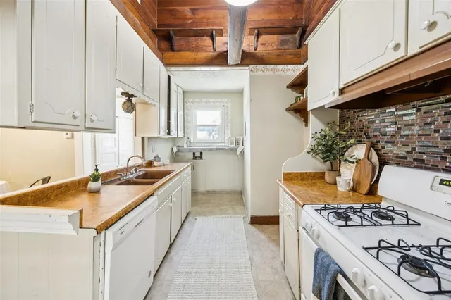a kitchen with a sink stove top oven and cabinets