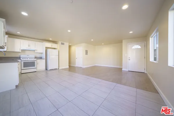 a view of kitchen with granite countertop cabinets and refrigerator