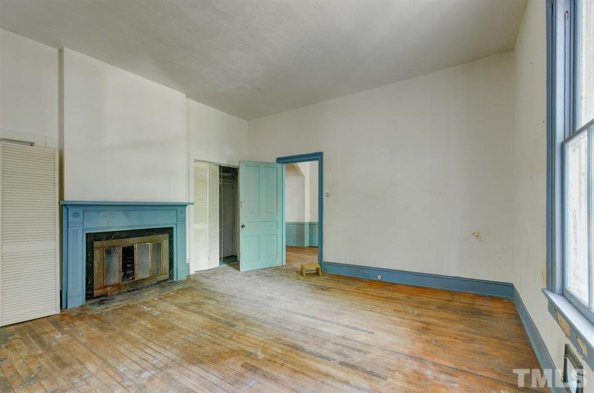 5816 Old Stage Road Raleigh, NC 27603 - Photo 19 of 30 a view of empty room with wooden floor and fireplace