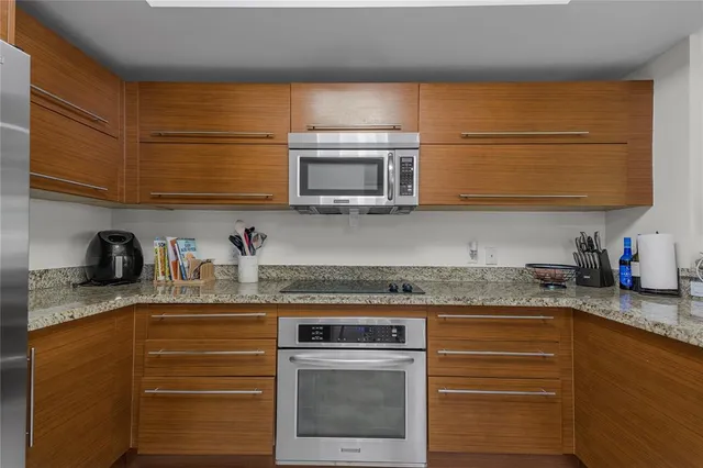 a kitchen with granite countertop a sink stainless steel appliances and cabinets