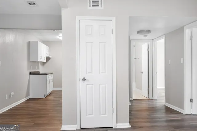 a view of empty room with wooden floor