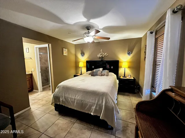 a bedroom with a bed mirror and a chandelier