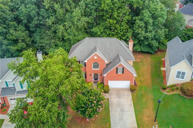 an aerial view of a house next to a yard with potted plants