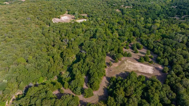 an aerial view of a houses with a yard and lake