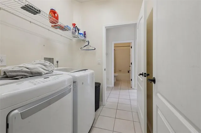 an empty room with a chandelier fan and wooden floor