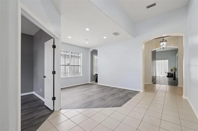 a view of a hallway with wooden floor and a living room