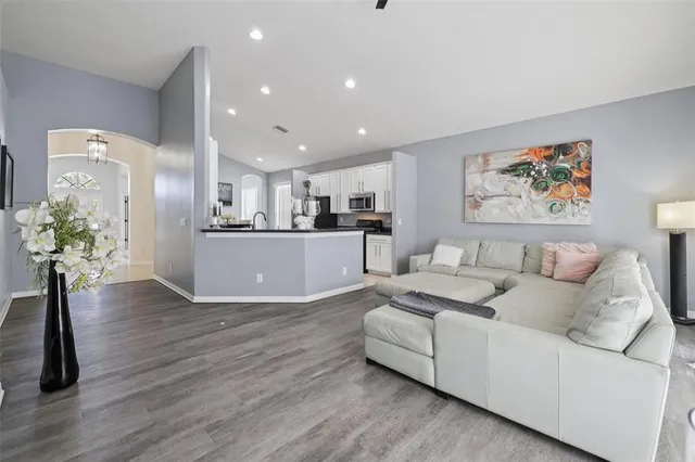 a living room with furniture and a dining table with kitchen view