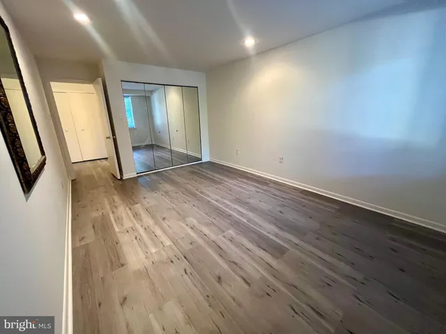 an empty room with wooden floor and mirror