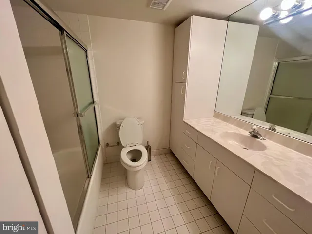 a bathroom with a sink and mirror with toilet