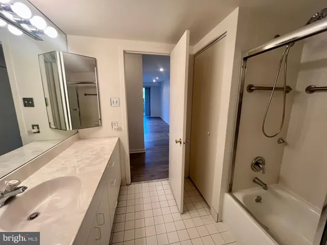 a bathroom with a tub sink and mirror