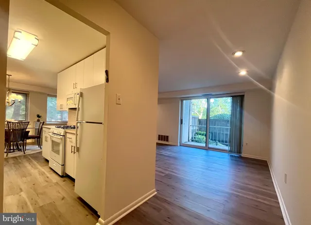 a view of a kitchen with wooden floor and a refrigerator