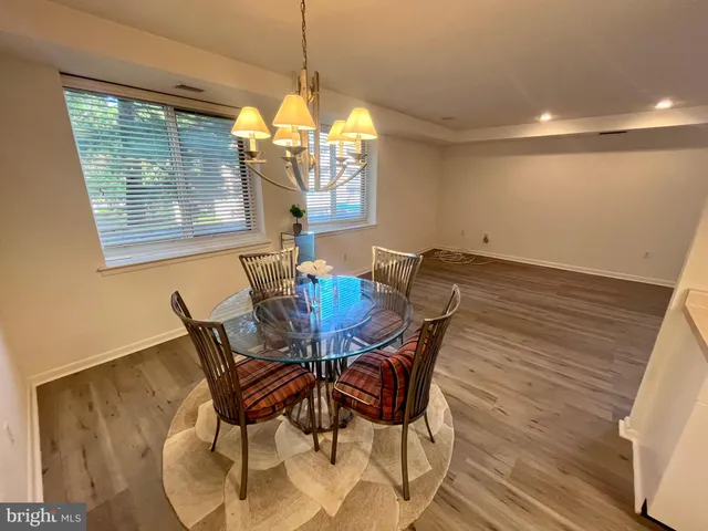 a view of a dining room with furniture a chandelier and wooden floor