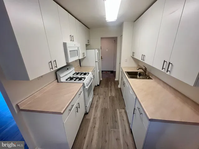 a kitchen with granite countertop a sink stove and refrigerator