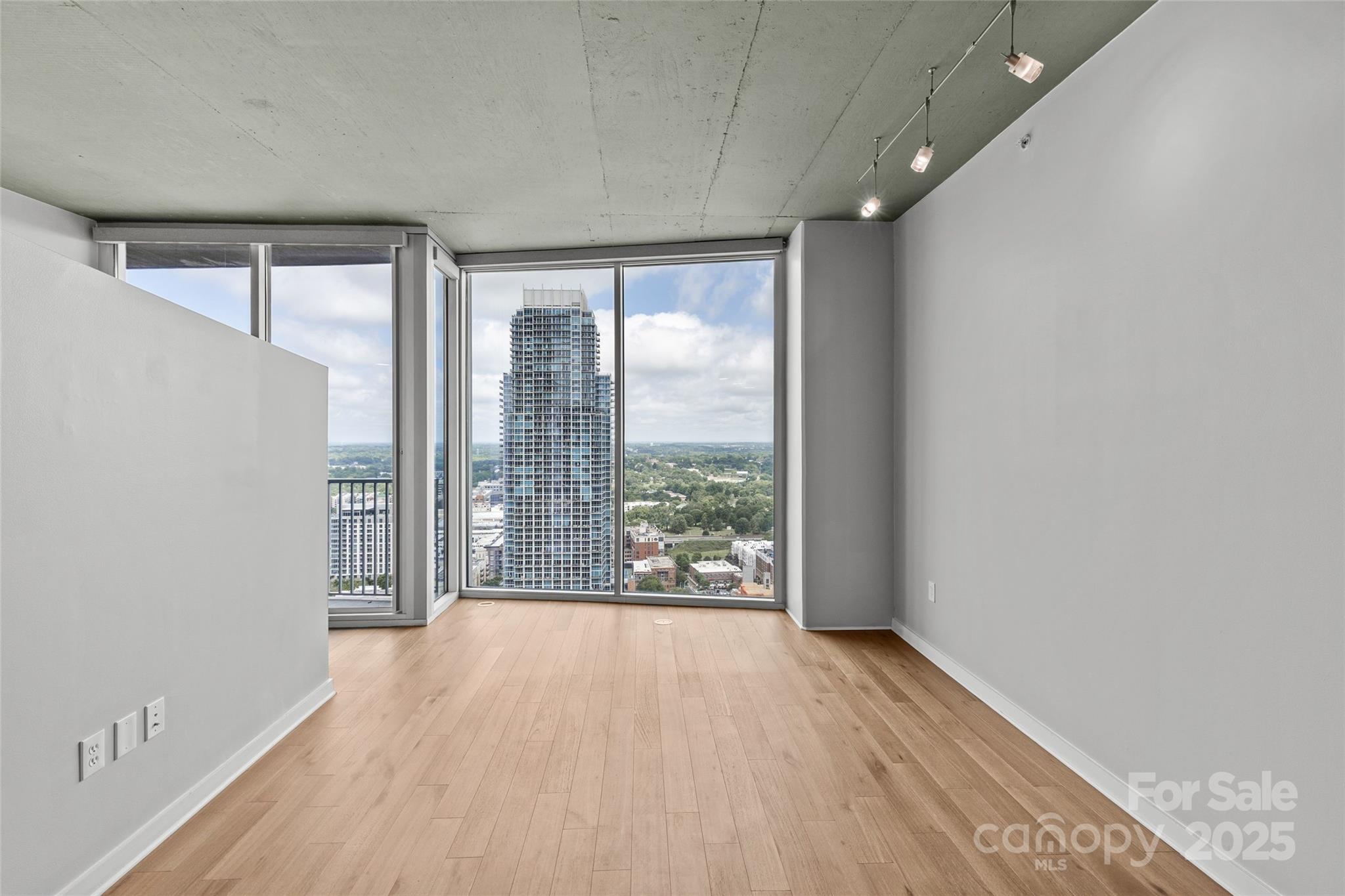 210 North Church Street, Unit 2910 Charlotte, NC 28202 - Photo 13 of 30 a view of an empty room with wooden floor and a window