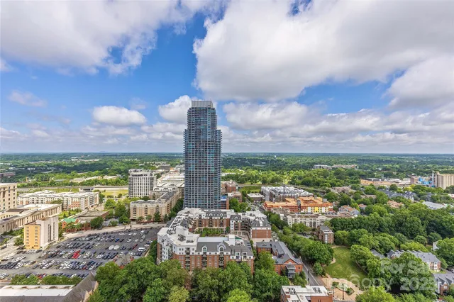 an aerial view of a city with lots of residential buildings ocean and mountain view in back