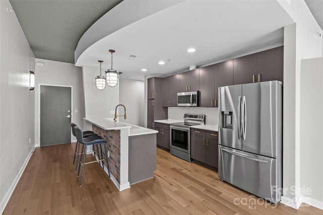 a kitchen with stainless steel appliances granite countertop a sink a stove and a refrigerator