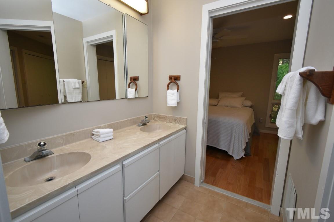 408 Constitution Drive Durham, NC 27705 - Photo 23 of 39 a en suite bathroom with a double vanity sink and mirror