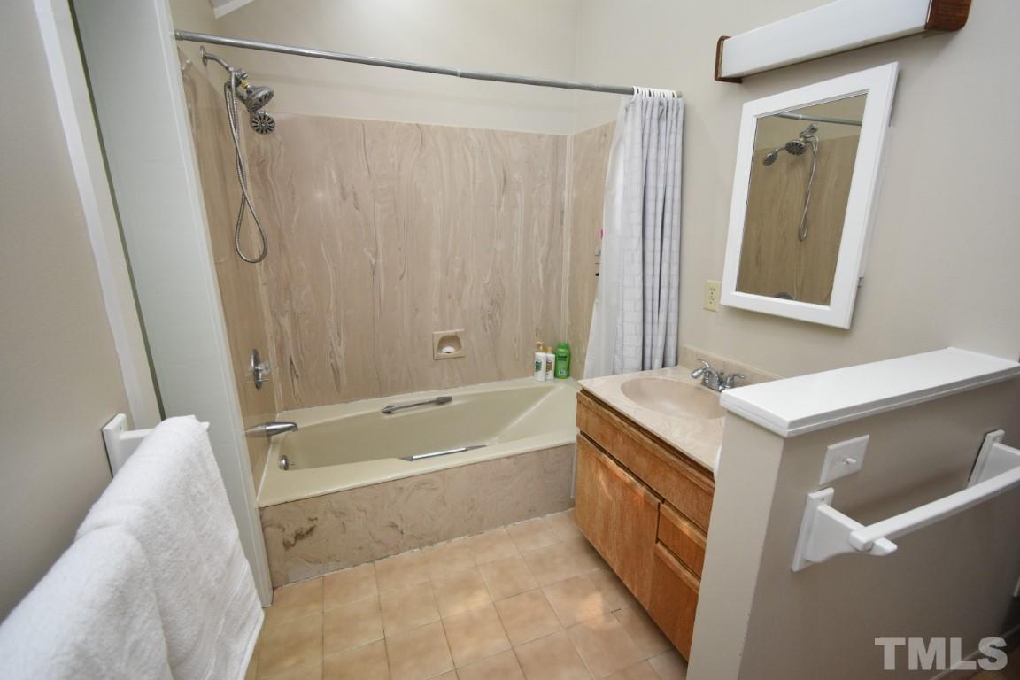 408 Constitution Drive Durham, NC 27705 - Photo 31 of 39 a bathroom with a tub sink vanity and mirror