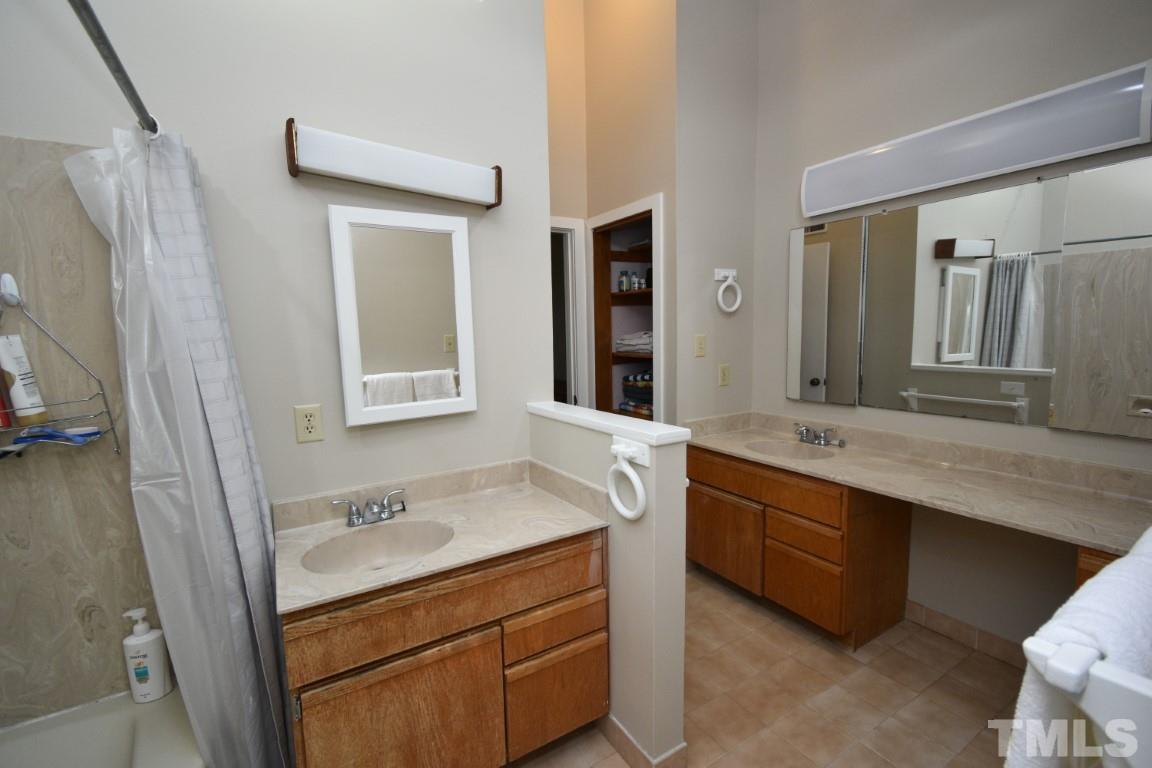 408 Constitution Drive Durham, NC 27705 - Photo 32 of 39 a bathroom with a granite countertop double vanity sink and mirror with bathtub