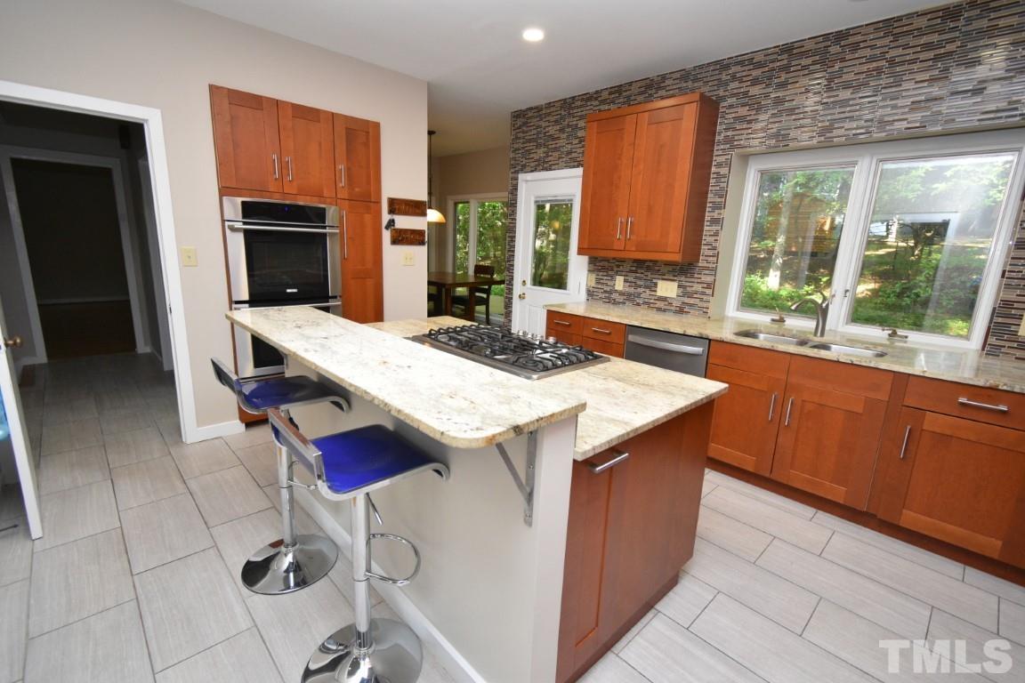 408 Constitution Drive Durham, NC 27705 - Photo 4 of 39 a kitchen with a stove a sink and a refrigerator