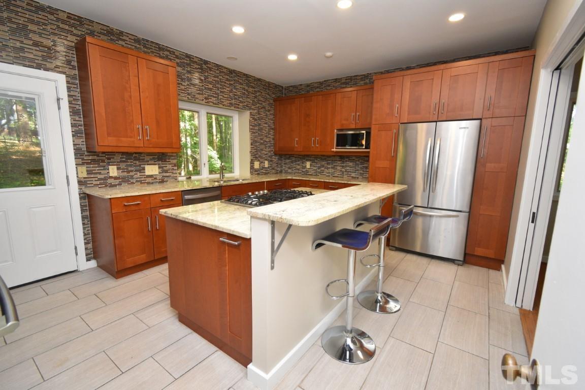 408 Constitution Drive Durham, NC 27705 - Photo 6 of 39 a kitchen with stainless steel appliances granite countertop a stove refrigerator and cabinets