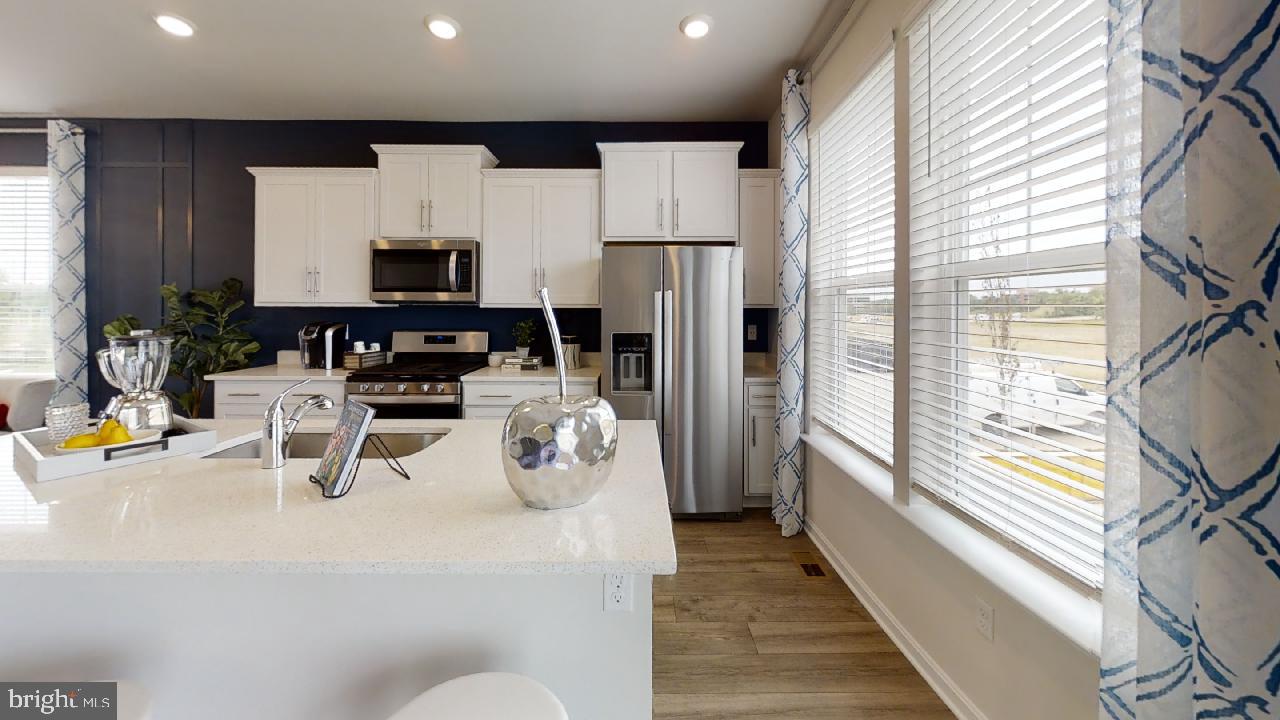 2113 Ruby Turn Bowie, MD 20721 - Photo 12 of 48 a kitchen with stainless steel appliances kitchen island granite countertop a refrigerator a stove a sink and white cabinets with wooden floor next to windows