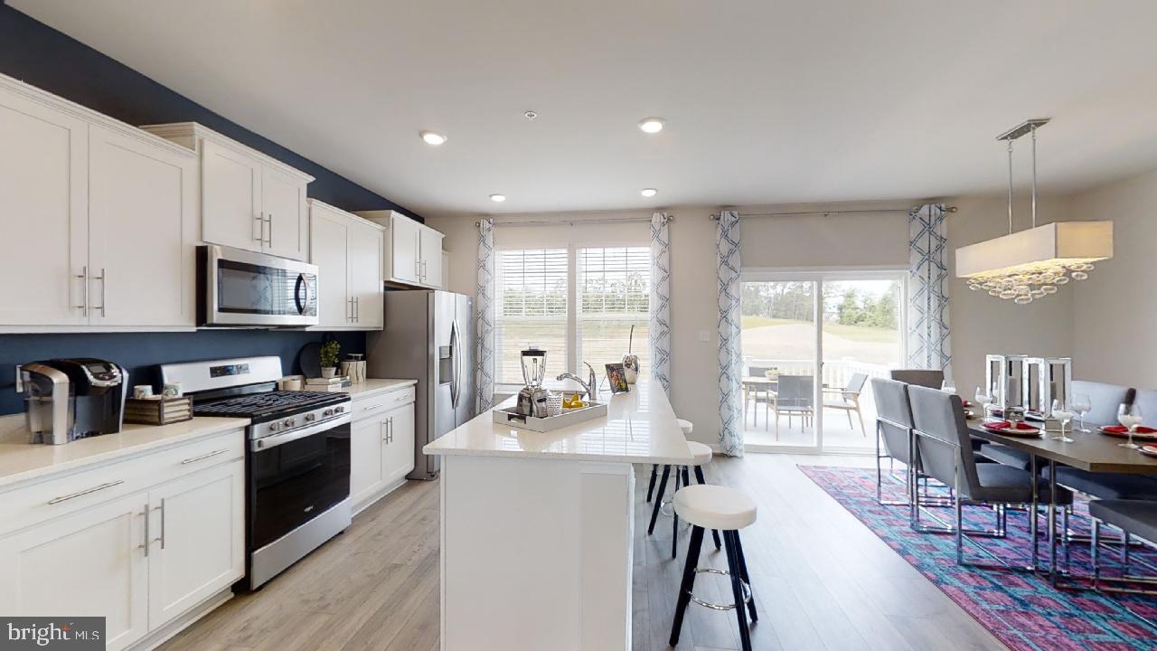 2113 Ruby Turn Bowie, MD 20721 - Photo 47 of 48 a kitchen with stainless steel appliances kitchen island granite countertop a stove top oven a sink a dining table and chairs with wooden floor