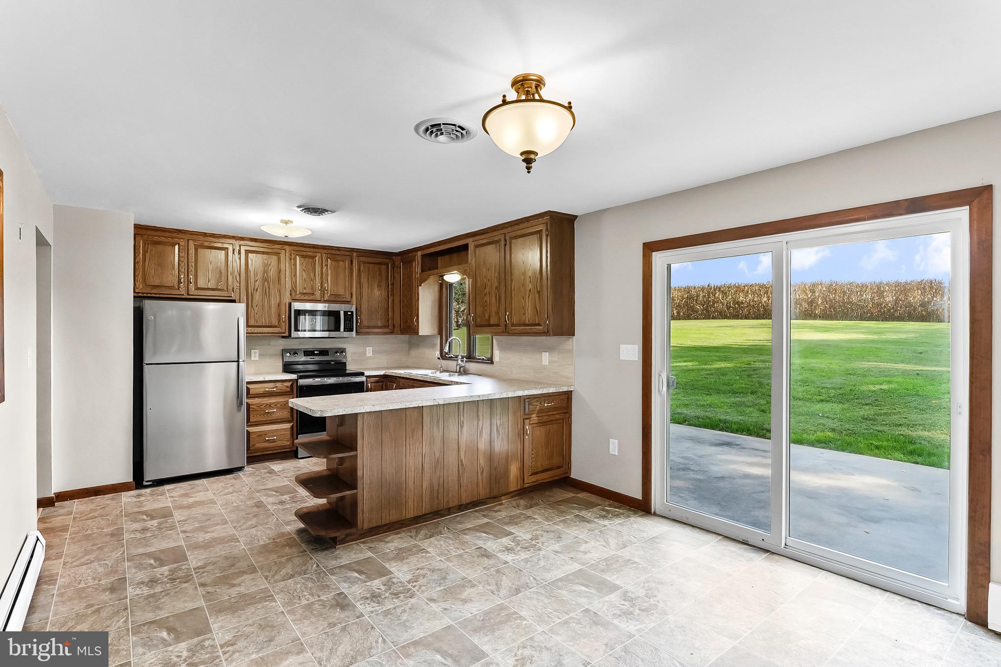 350 Roneys Corner Road Oxford, PA 19363 - Photo 8 of 18 a kitchen with stainless steel appliances granite countertop a stove a refrigerator and a view of living room
