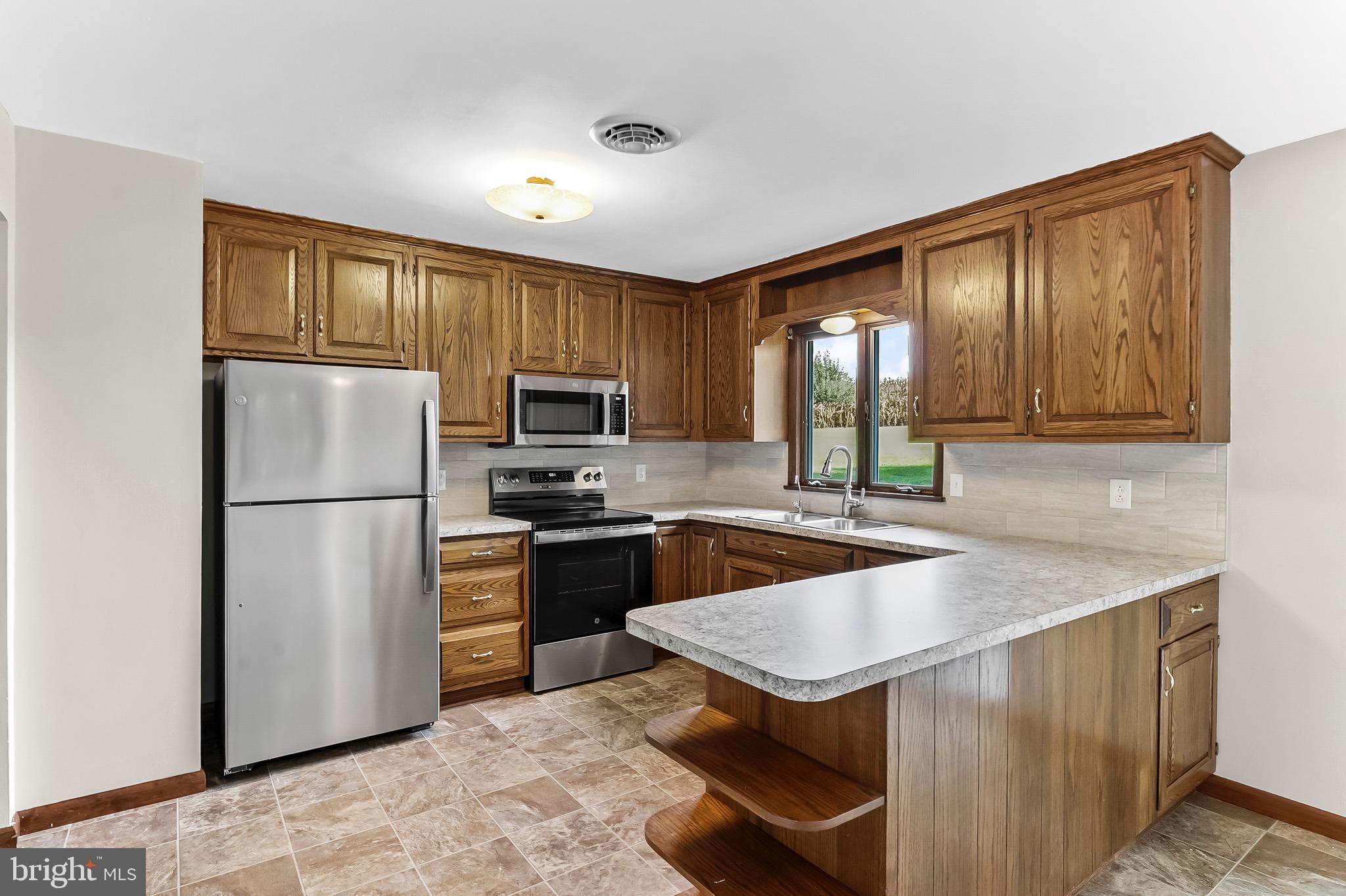 350 Roneys Corner Road Oxford, PA 19363 - Photo 9 of 18 a kitchen with stainless steel appliances granite countertop a refrigerator stove microwave and sink