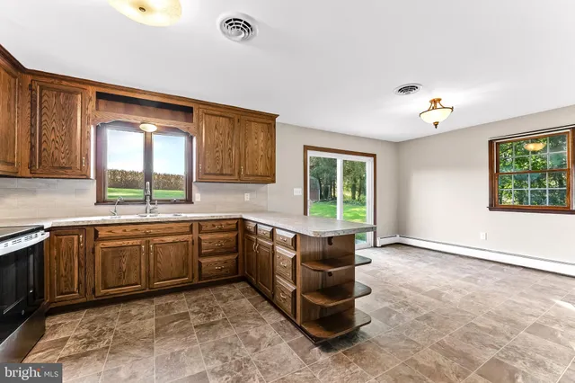 a large kitchen with kitchen island granite countertop a stove a sink and a dishwasher
