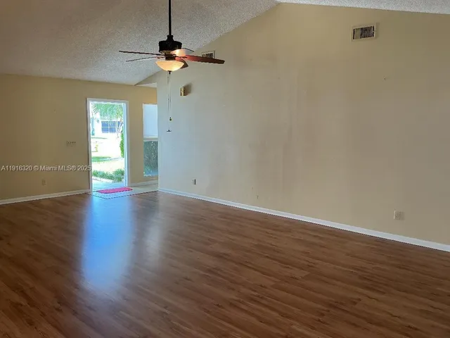 a view of an empty room with wooden floor