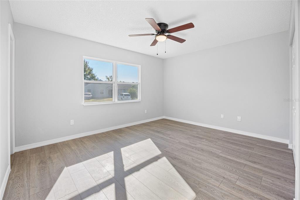 2 Oak Court Pass Ocala, FL 34472 - Photo 12 of 28 an empty room with wooden floor fan and windows