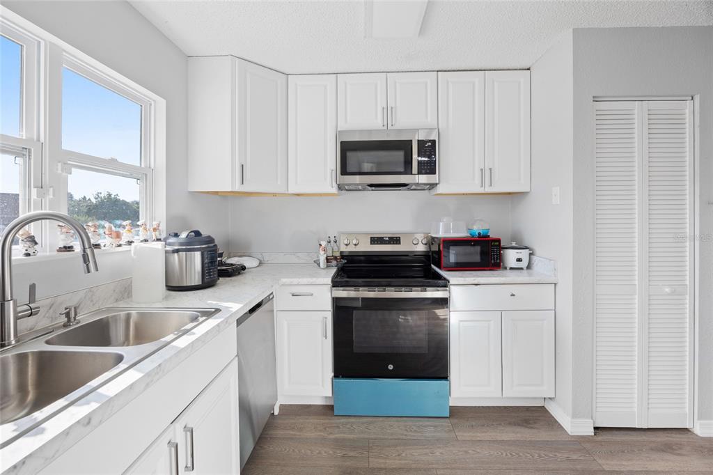 2 Oak Court Pass Ocala, FL 34472 - Photo 5 of 28 a kitchen with stainless steel appliances granite countertop a sink dishwasher a stove and a microwave oven with cabinets