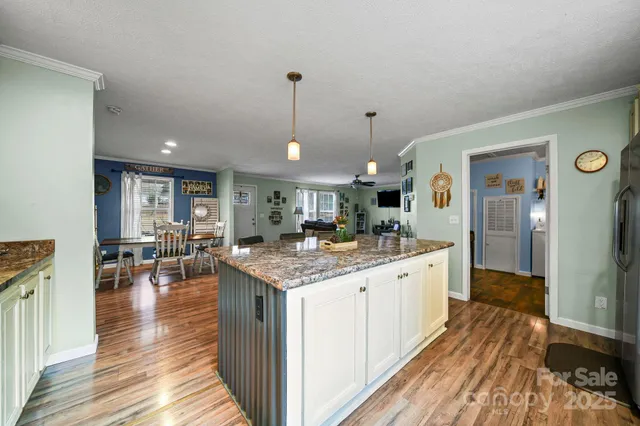 a large kitchen with stainless steel appliances granite countertop a lot of counter space and wooden floors