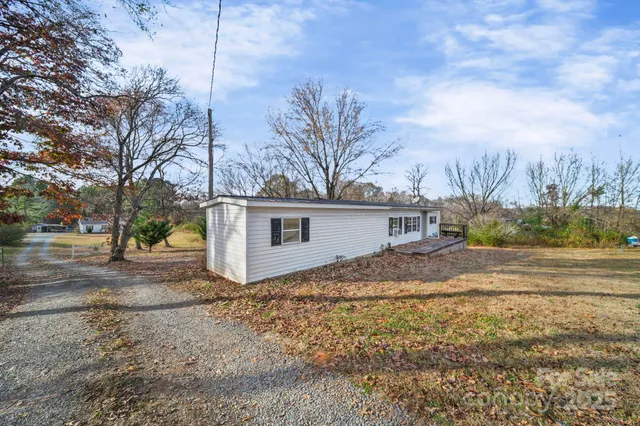 a view of a house with a yard covered in the forest