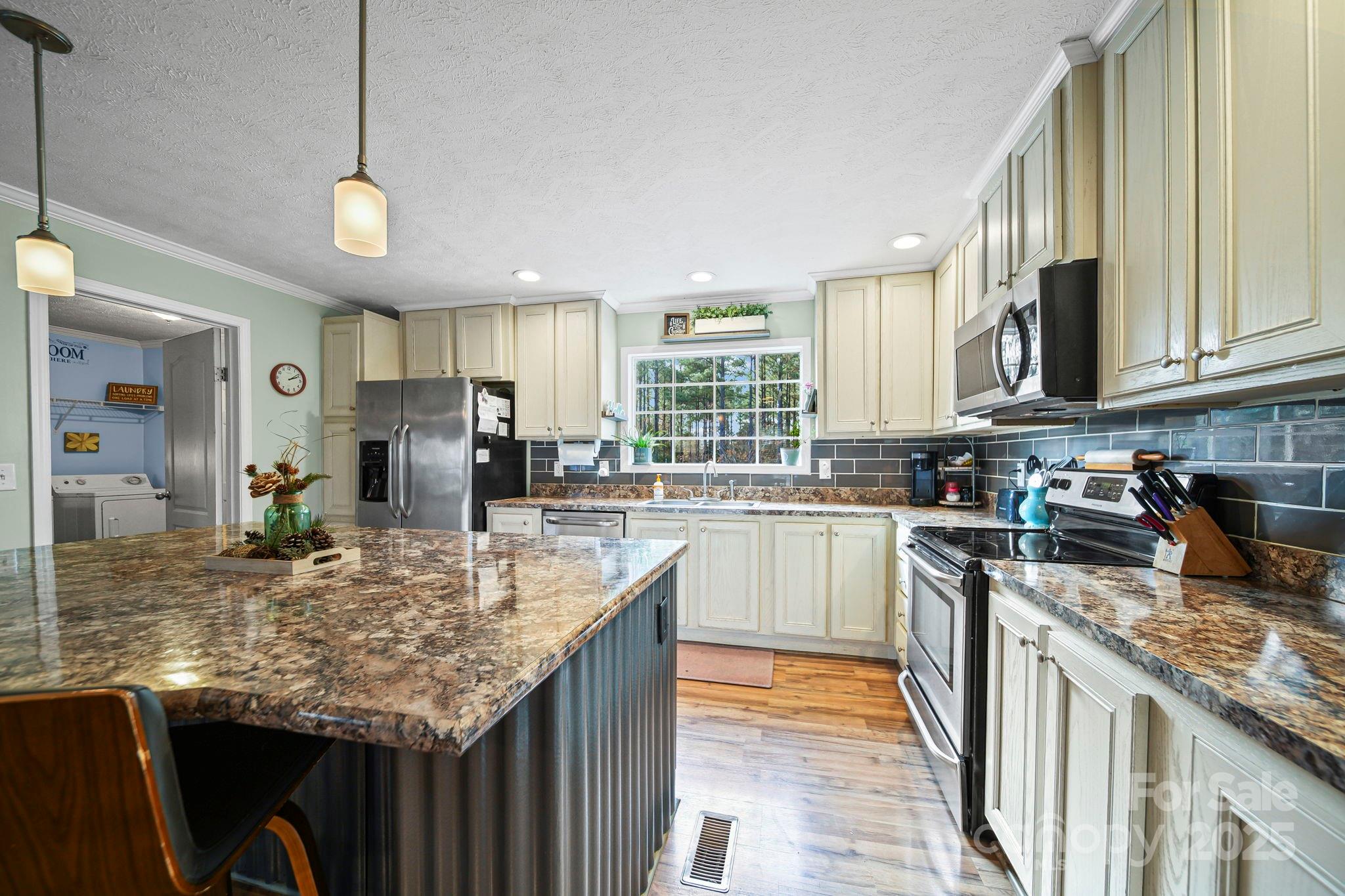 30291 C Red Hill Road Albemarle, NC 28001 - Photo 9 of 45 a kitchen with stainless steel appliances granite countertop a sink a stove top oven a refrigerator cabinets and wooden floor